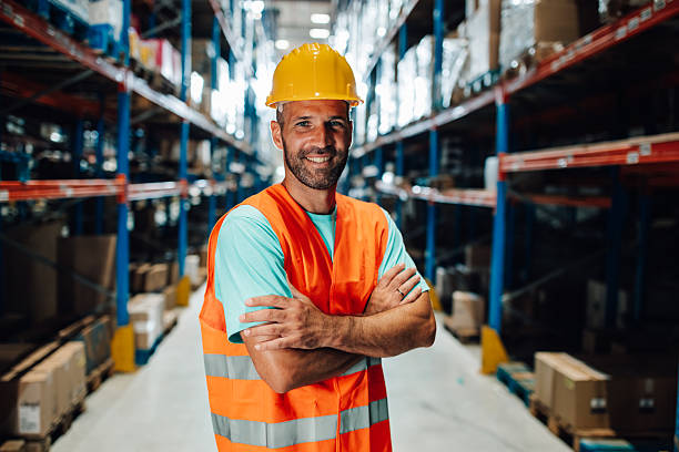 istock Warehouse worker smiling with crossed arms in logistics center 2204342460