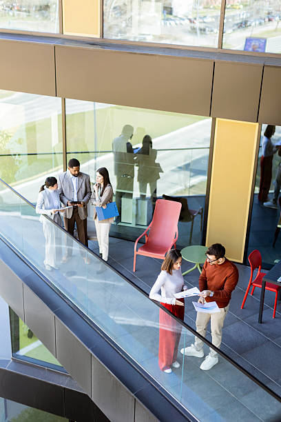 Colleagues engage in a productive discussion on a modern office balcony during a sunny afternoon