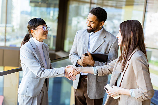 istock Business professionals engage in productive conversation at modern office setting in daylight 2204345650