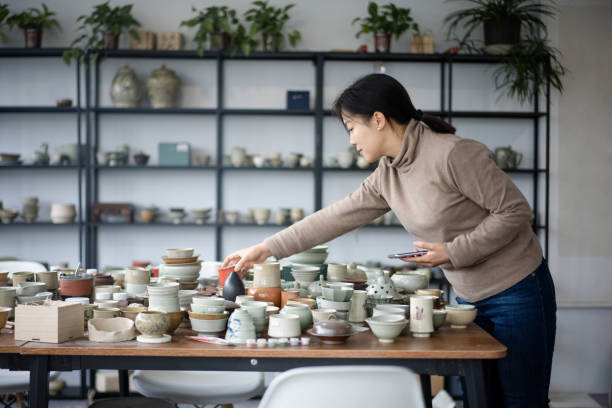 asian female potter using smartphone