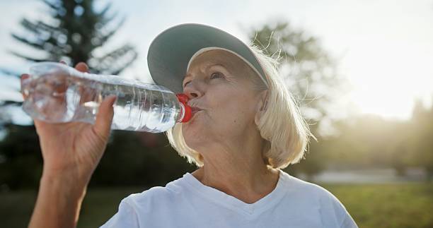 istock An Elderly Woman Happily Drinking Refreshing Water While Enjoying the Outdoors in Sunlight 2204345868