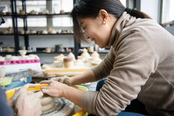 istock Confident craftsperson molding clay on pottery wheel at workshop 2204346573