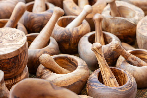istock Rustic wooden mortars and pestles carved from solid wood with smooth polished surfaces and natural grain patterns arranged for sale 2204346707