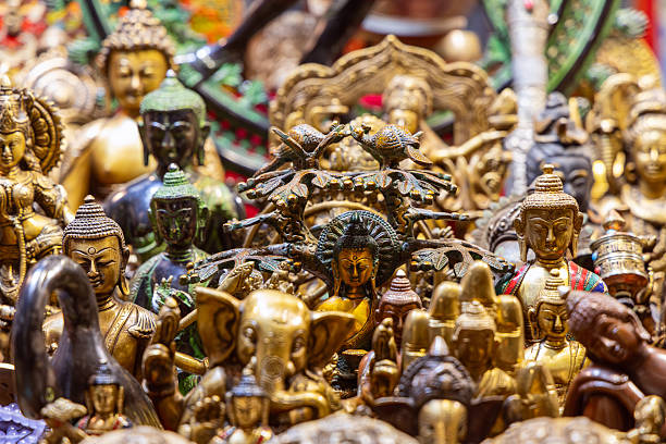 istock Dense display of Hindu and Buddhist deity statues crafted from metal with gold and bronze tones featuring intricate carvings and symbolic elements at a market stall 2204346708
