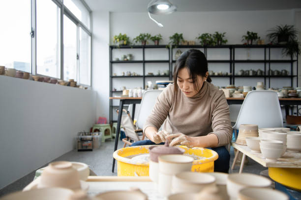 istock Confident craftsperson molding clay on pottery wheel at workshop 2204346852