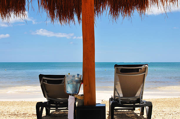 Two sun loungers and an umbrella on a Caribbean beach