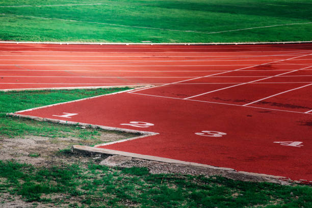 istock Empty athletics track with starting lanes and lush green grass surrounding, ready for runners in the early morning light 2204350748