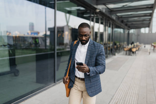 istock Man strolling with smartphone outside vibrant airport 2204350814