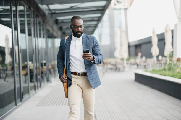 istock Focused man walking with smartphone at airport 2204352475