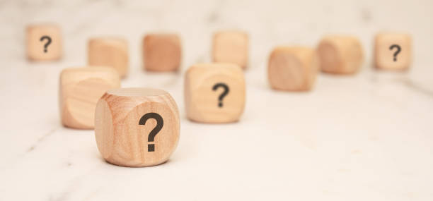 istock wooden blocks with question marks on a marble surface, symbolizing uncertainty and curiosity 2204353177