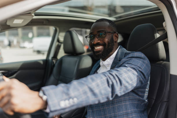 istock Stylish man driving a car, smiling with confidence 2204353293