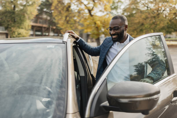 istock Happy man getting into a car on a sunny day 2204353526