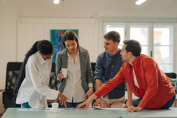 Marketing team analyzing charts and discussing strategy in modern office