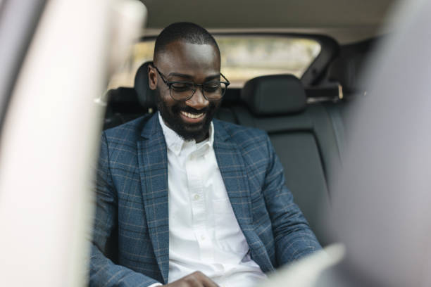 istock Cheerful Man Using Tablet in Backseat of a Car 2204354100