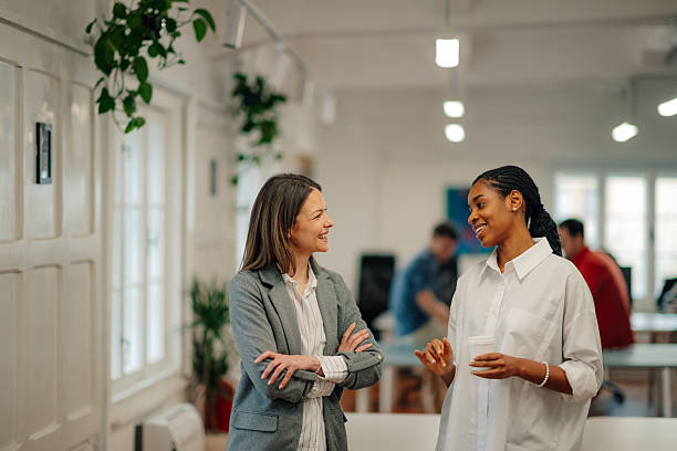 istock Two businesswomen talking during coffee break in modern office 2204354182