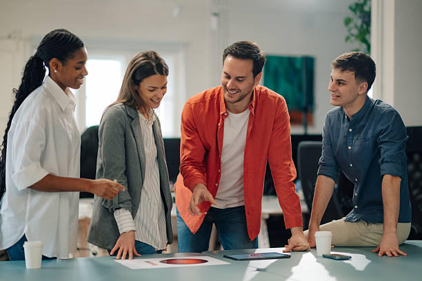 istock Marketing team analyzing charts and working on tablet in office meeting 2204354221