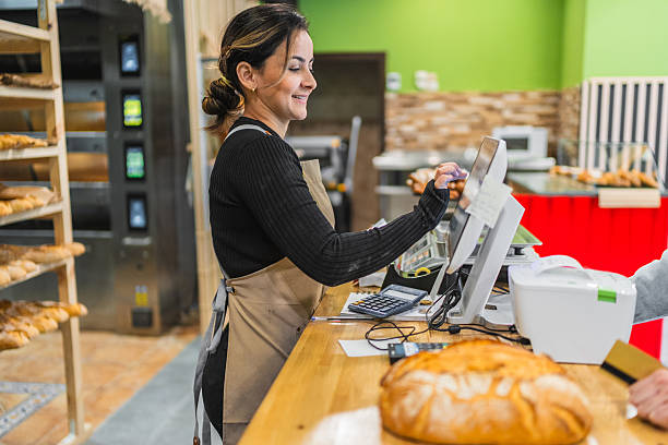 istock Baker entering customer order on cash register in bakery 2204354541