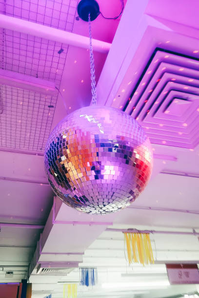 A large disco ball hangs from the ceiling, illuminating the space