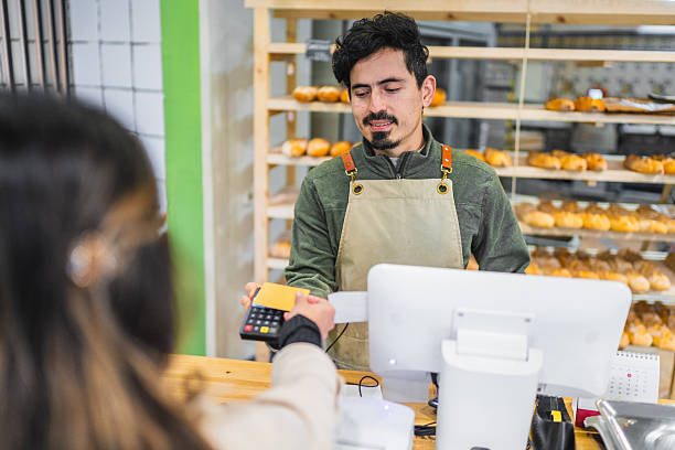 istock Baker accepting contactless payment from customer in bakery shop 2204354675