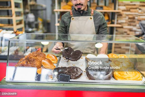 Baker Display. Try Baker Picking Up A Pastry From Display Case In Bakery Stock Photo ...