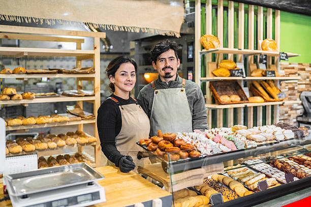 istock Bakers smiling at the camera in their bakery shop 2204354892