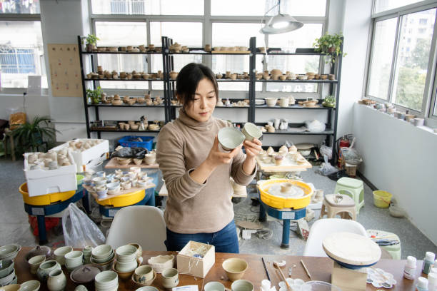 istock Asian woman is selecting cups in a pottery studio 2204355386