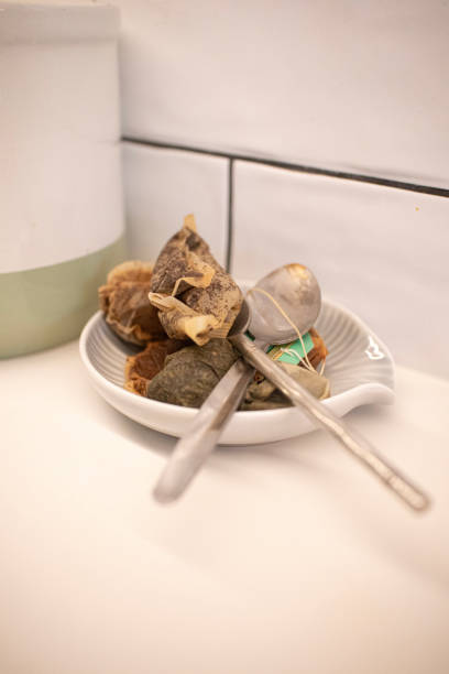 Old used teabags on a kitchen counter with teaspoons