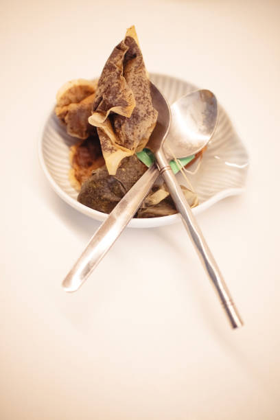Old used teabags on a kitchen counter with teaspoons