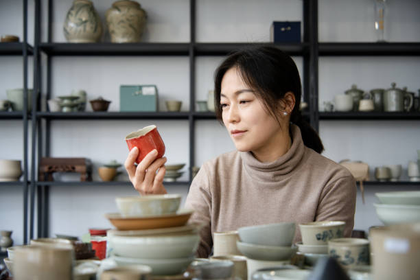 istock Asian woman is selecting cups in a pottery studio 2204356265