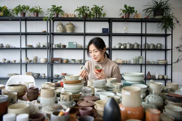 istock Asian woman is selecting cups in a pottery studio 2204356557