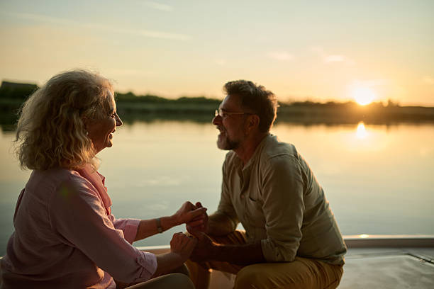 istock Senior couple holding hands enjoying romantic sunset boat trip 2204356745