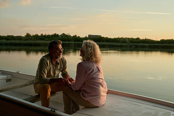 istock Senior couple holding hands and enjoying a romantic sunset boat ride 2204356749