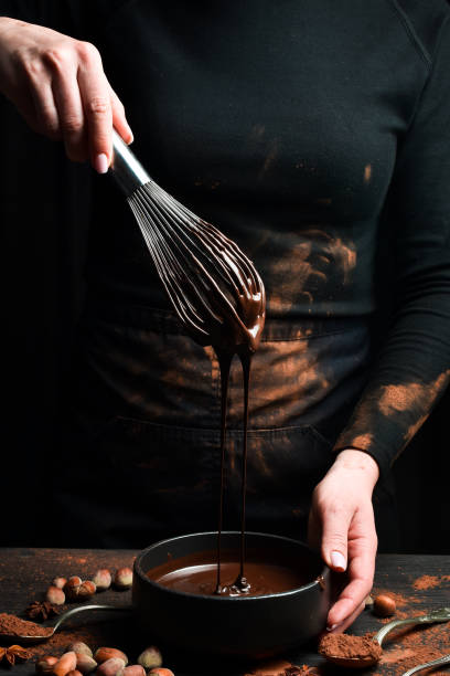 istock Kitchen metal whisk in chocolate. Kitchen utensils. On a black background. 2204356842