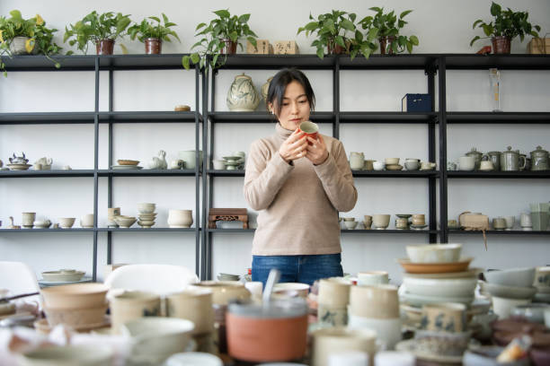 istock Asian woman is selecting cups in a pottery studio 2204356929