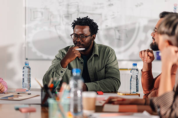 istock Thoughtful marketing professional pondering during office meeting 2204358510