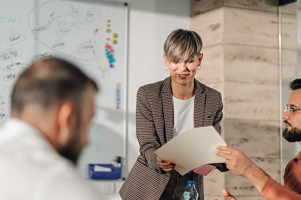 istock Businesswoman sharing documents with colleagues during office meeting 2204358539