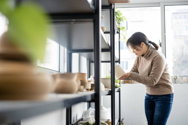 istock Asian woman is selecting cups in a pottery studio 2204358859