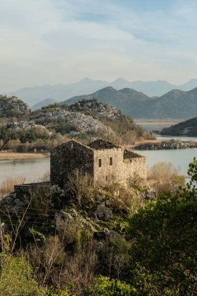 istock Stone building by a tranquil lake and mountains. 2204360852
