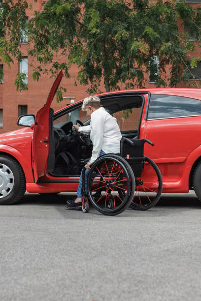 istock Businesswoman, a driver with a disability getting into a red car 2204360853