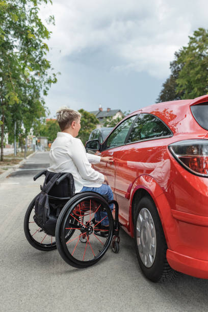 istock Businesswoman, a driver with a disability getting into a red car 2204360970