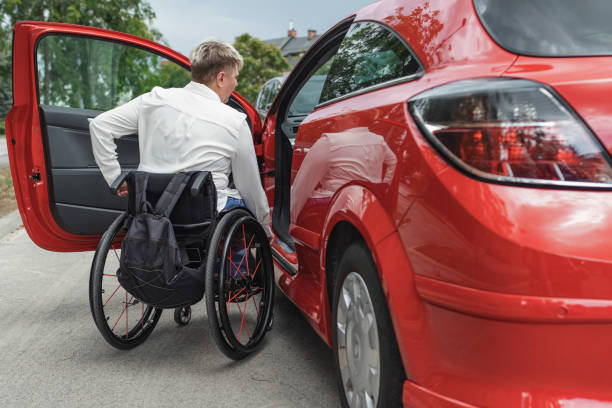 istock Businesswoman, a driver with a disability getting into a red car 2204361700