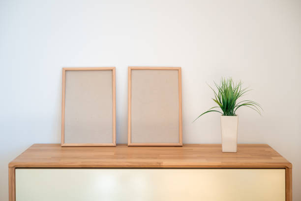 istock Empty wooden picture frames as mockup copy space placed on oakwood cabinet 2204361781