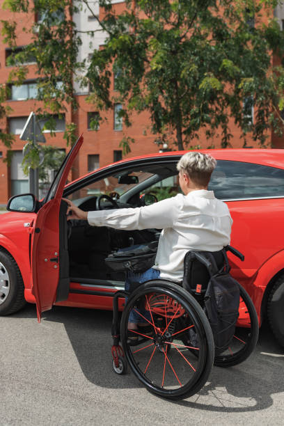 istock Businesswoman, a driver with a disability getting into a red car 2204361984