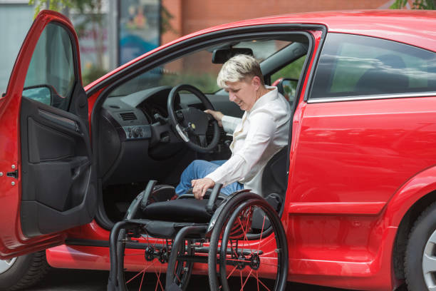 istock Businesswoman, a driver with a disability getting into a red car 2204361996