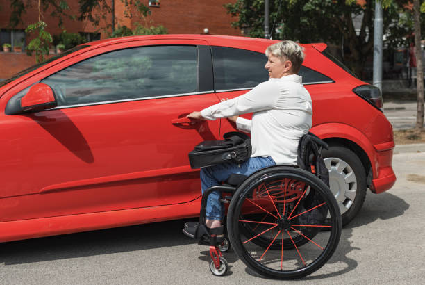 istock Businesswoman, a driver with a disability getting into a red car 2204362000