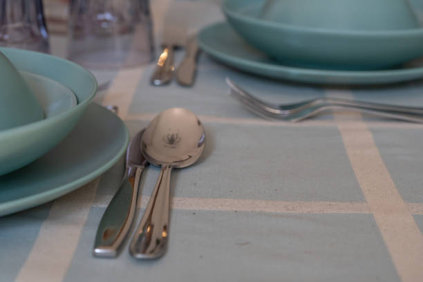 Elegant table setting in a modern kitchen with plates, cutlery, and glasses.