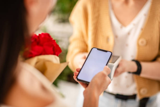 istock Paying with a smartphone for flowers at a flower shop using wireless technology 2204363876