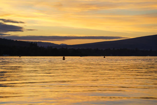Composite image simulating a sunset over a harbour in Loch Lomond in Scotland, UK.