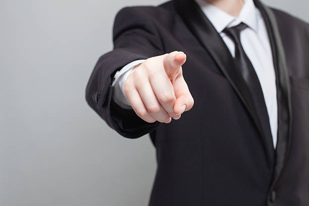 istock Businessman in black suit poingting on camera. 2204364163