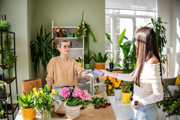 istock Paying with wireless technology for flowers at a modern florist shop 2204364179